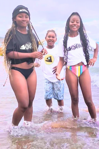 3 junge Frauen mit langen Haaren am Strand im Wasser mit Hi-Fish T-Shirts 3 mujeres jóvenes con el pelo largo en la playa en el agua con camisetas Hi-Fish