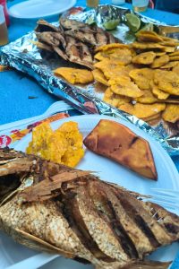 Dominikanischer Fisch und frittierte Platanen auf blauem Tischtuch Pescado dominicano y plátanos fritos sobre un mantel azul
